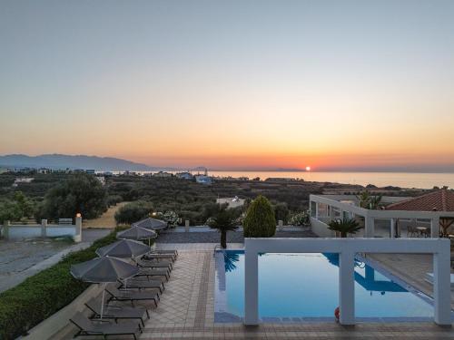 a villa with a swimming pool at sunset at Lofos Panorama Apartments in Prínos