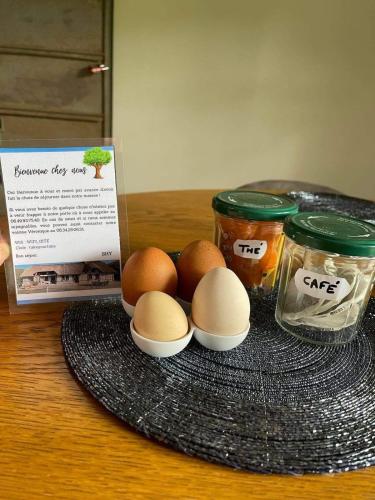 a plate with eggs and jars of food on a table at La Chaumière aux Animaux in Touffreville-la-Corbeline