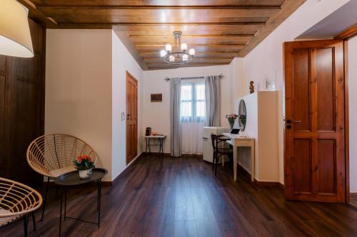 a living room with wooden ceilings and a table and chairs at Zacosta Villa Hotel in Rhodes Town