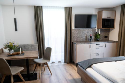 a bedroom with a bed and a desk and a table with chairs at Gasthof Schöntal in Werfenweng
