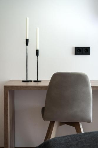 a table with two candles and a chair at Gasthof Schöntal in Werfenweng
