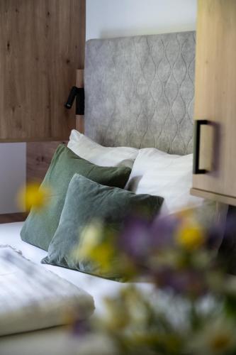 a bedroom with a bed with green and white pillows at Gasthof Schöntal in Werfenweng