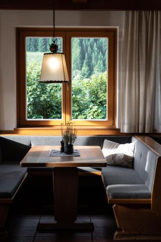 a table and a couch in front of a window at Gasthof Schöntal in Werfenweng