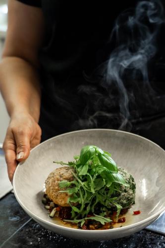 a person holding a plate of food with smoke at Gasthof Schöntal in Werfenweng