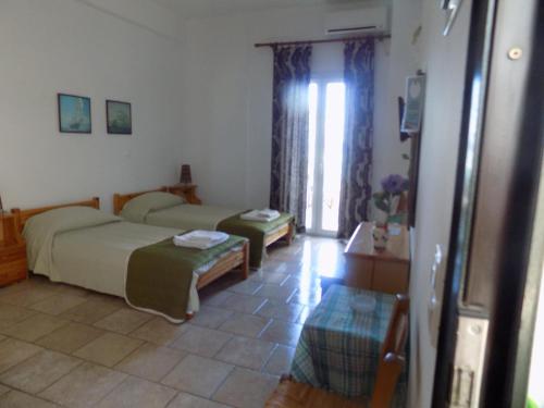a bedroom with two beds and a table in it at Armenistis View Studios in Armenistis