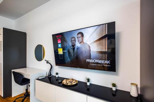 a flat screen tv hanging on a wall in a room at Lilly Studio Axxis Beach in Mamaia