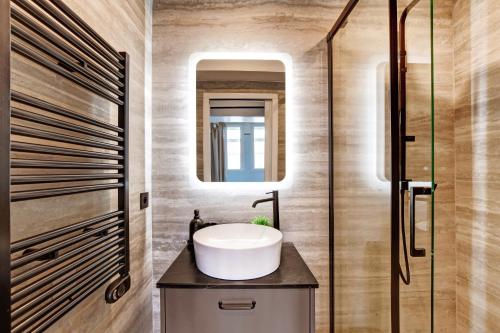 une salle de bain avec un lavabo et un miroir dans l'établissement Pick A Flat's Apartments in Daumesnil - Avenue du General Bizot, à Paris