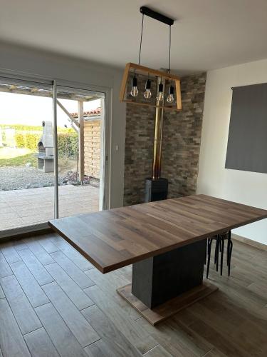- une grande table en bois dans le salon dans l'établissement maison au calme, à Maubourguet