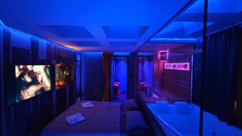 a room with a bed and a tv and blue lights at PentLux - SPA Penthouse in the heart of Skopje in Skopje