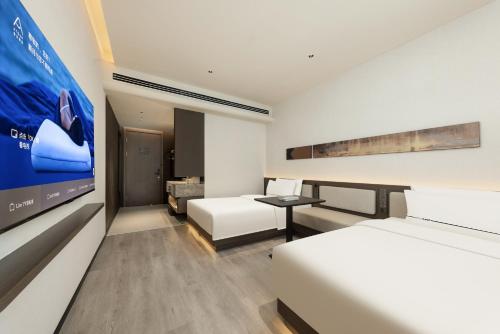 a hotel room with a bed and a flat screen tv at Atour Hotel Wenzhou Wuma Street Pedestrian Street in Wenzhou