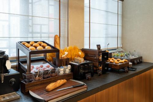 a breakfast buffet with bread and pastries on a counter at Atour Hotel Wenzhou Wuma Street Pedestrian Street in Wenzhou