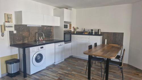une cuisine avec une machine à laver et une table dans l'établissement Life in red with parking and air conditioning, à Sète
