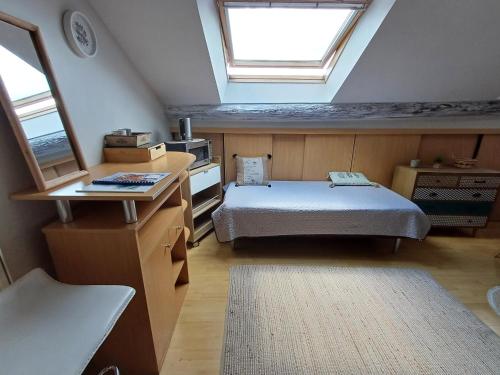 a attic room with a bed and a window at L'étoile du matin in Terville