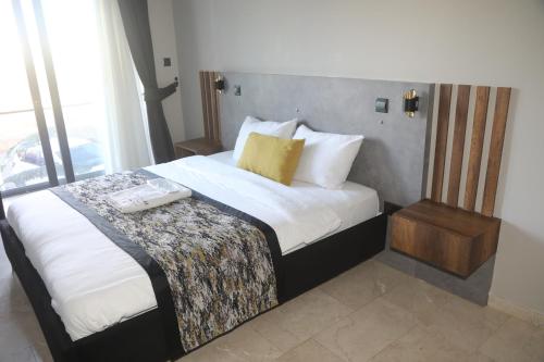 a hotel room with a bed with white sheets at Del Mare Park in Kérynia