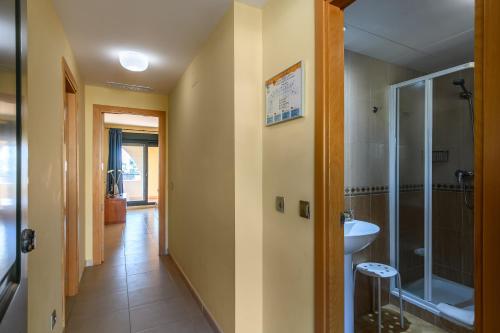 ein Flur mit einem Badezimmer mit Dusche und Waschbecken in der Unterkunft Playa Marina by Ĥ - Playa Punta del Moral PPHM303P59 in Punta del moral
