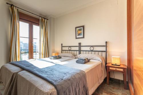 a bedroom with a large bed and a window at El Rincón del Golf III by Ĥ - Isla Canela Golf GRHIII88P88 in Isla Canela