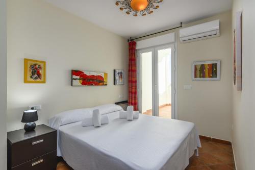 une chambre blanche avec un lit et une fenêtre dans l'établissement Mirador del Guadiana - Ayamonte AMHG27P27, à Ayamonte