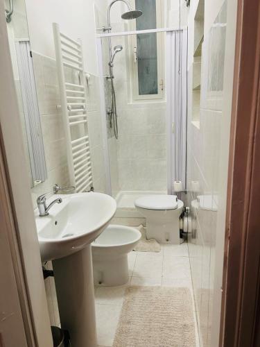 a white bathroom with a sink and a toilet at Casa Vacanze Angelina in Trieste