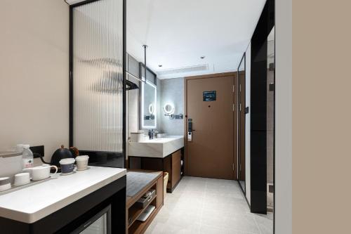 a bathroom with a sink and a mirror at Atour Hotel Quanzhou Nan'an Shuitou Anping Bridge in Quanzhou