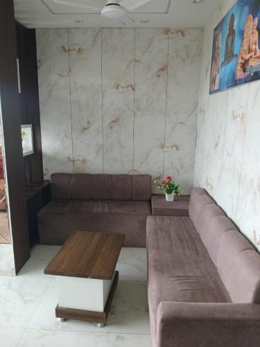 a living room with a couch and a coffee table at Hotel New Arcadia in Bhopal