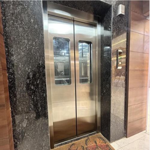 a metal elevator in a building with a floor at Hotel New Arcadia in Bhopal