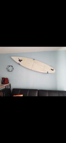 une planche de surf accrochée à un mur dans une pièce dans l'établissement Appart Seignosse Le Penon, à Seignosse