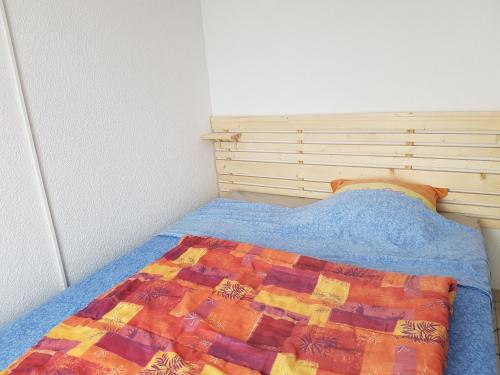 une chambre avec un lit avec une couette dessus dans l'établissement Appart Seignosse Le Penon, à Seignosse
