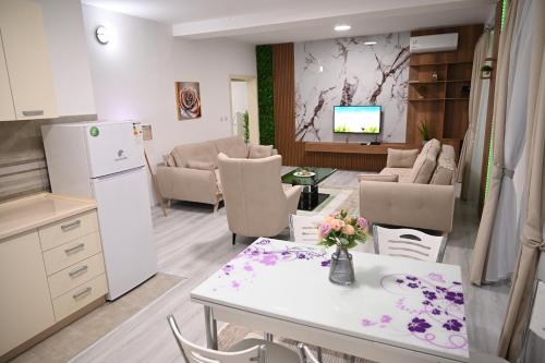 a kitchen and living room with a table and chairs at Apartmani P7 in Dračevo