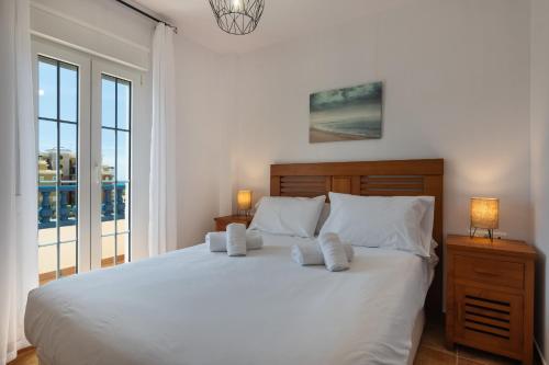 ein Schlafzimmer mit einem großen Bett mit weißen Laken und Kissen in der Unterkunft Marina I PLUS by Ĥ - Marina Isla Canela PMHI57P28 in Punta del moral