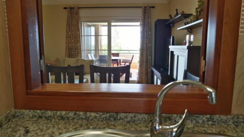 ein Spiegel über einer Spüle in einer Küche mit Esszimmer in der Unterkunft Las Marismas by Ĥ - Isla Canela Golf GLHM117P134 in Isla Canela