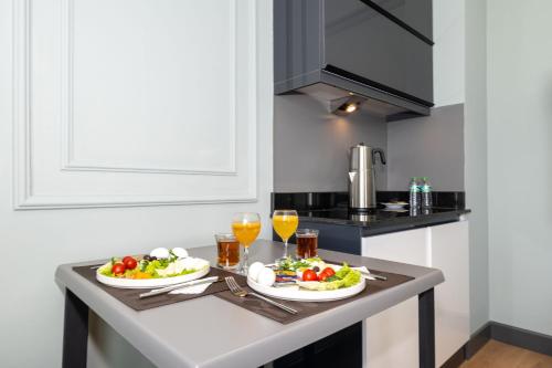 a kitchen with two plates of food and glasses of orange juice at Rusel Park Residence in Bahcesehir