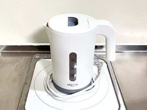 a white blender sitting on top of a washing machine at Discover Fukuoka House in Fukuoka