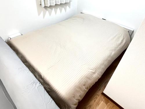 a bed in a corner of a room at Discover Fukuoka House in Fukuoka