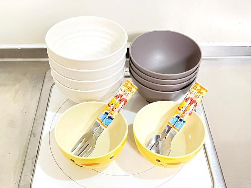two forks and plates and bowls on a glass tray at Discover Fukuoka House in Fukuoka