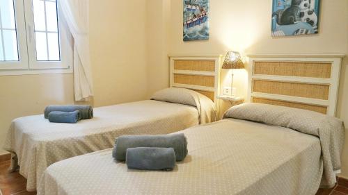 a room with three beds with towels on them at Marina III by Ĥ - Marina Isla Canela PMHIII12P13 in Isla del Moral