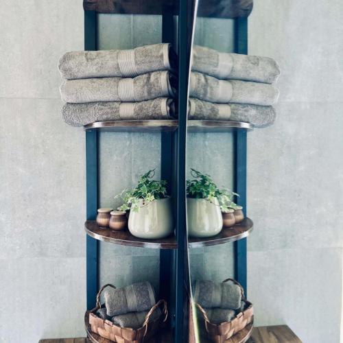a towel rack with towels and potted plants on it at LasMinute - stodoła z prywatną balią in Kazimierzów