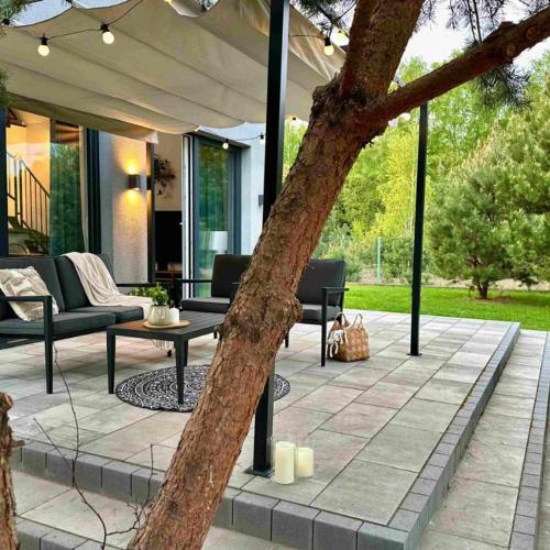 an outdoor patio with a table and a tree at LasMinute - stodoła z prywatną balią in Kazimierzów