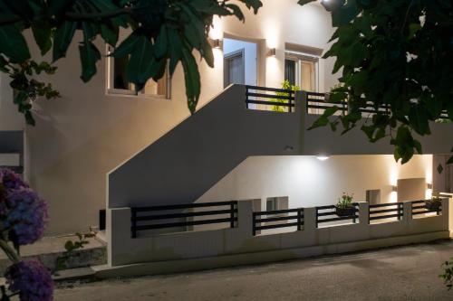 a building with a staircase with benches and flowers at Zerynthos Apartments in Therma