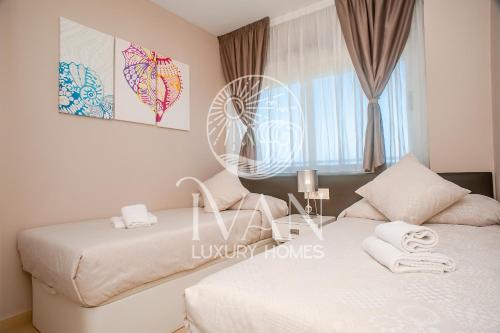 ein Schlafzimmer mit zwei Betten und einem Fenster in der Unterkunft Casa Cristal Ivan Luxury Homes 5ªPlta Sur 1ªLinea in Oropesa del Mar