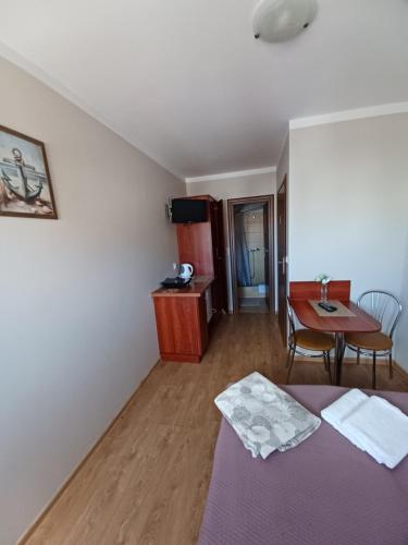 ein Zimmer mit einem Bett und einem Tisch und einem Schreibtisch in der Unterkunft Pensjonat Pod ósemką Mielno in Mielno
