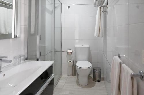 biała łazienka z toaletą i umywalką w obiekcie Alvear Suites w mieście Redondela