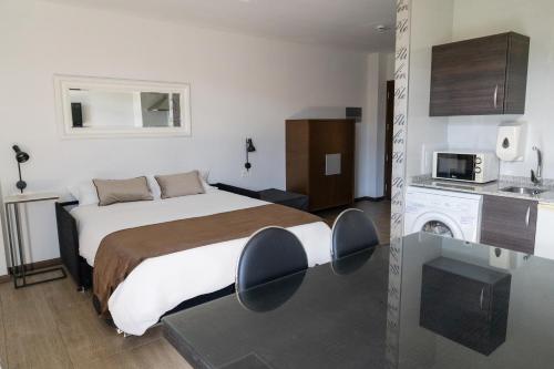 pokój hotelowy z łóżkiem i kuchnią w obiekcie Alvear Suites w mieście Redondela