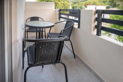 a patio with two chairs and a table on a balcony at Zerynthos Apartments in Therma