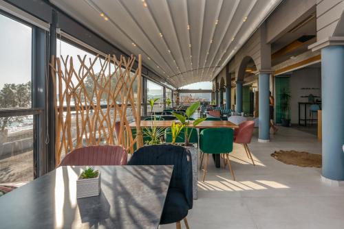 a restaurant with tables and chairs and windows at Christina Beach Hotel in Kissamos