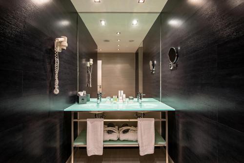 a bathroom with a sink and a mirror at Hotel Diagonal Plaza in Zaragoza