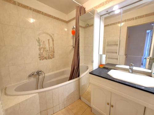 une salle de bain avec une baignoire, un lavabo et un miroir dans l'établissement Bienvenue à La Seyne-sur-Mer ! 2 chambres, climatisation, Wifi, à La Seyne-sur-Mer
