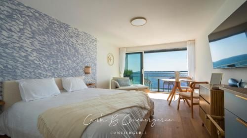 - une chambre avec un lit et une table avec un balcon dans l'établissement Le RÊVE BLEU CONCARNEAU 2 pers face à la mer, à Concarneau