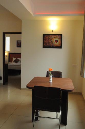 a dining room with a wooden table and chairs at Ixora Suites in Bengaluru