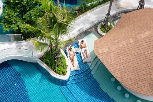an image of a swimming pool with a picture of a woman at Wyndham Garden Naithon Phuket in Nai Thon Beach