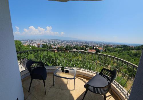 a balcony with two chairs and a table with a view at View Inn Boutique Hotel in Skopje